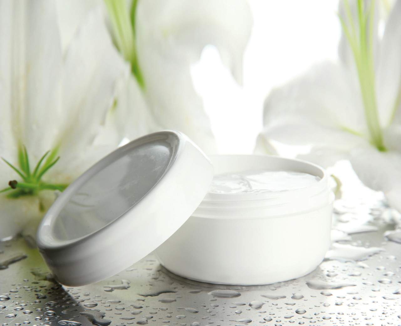 Cosmetic cream and beautiful lily, close up