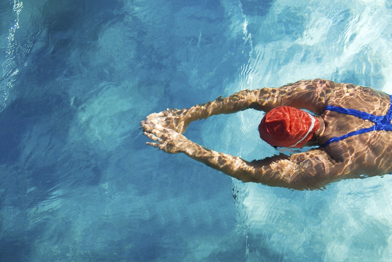 Athletic swimmer is diving in a swimming pool
